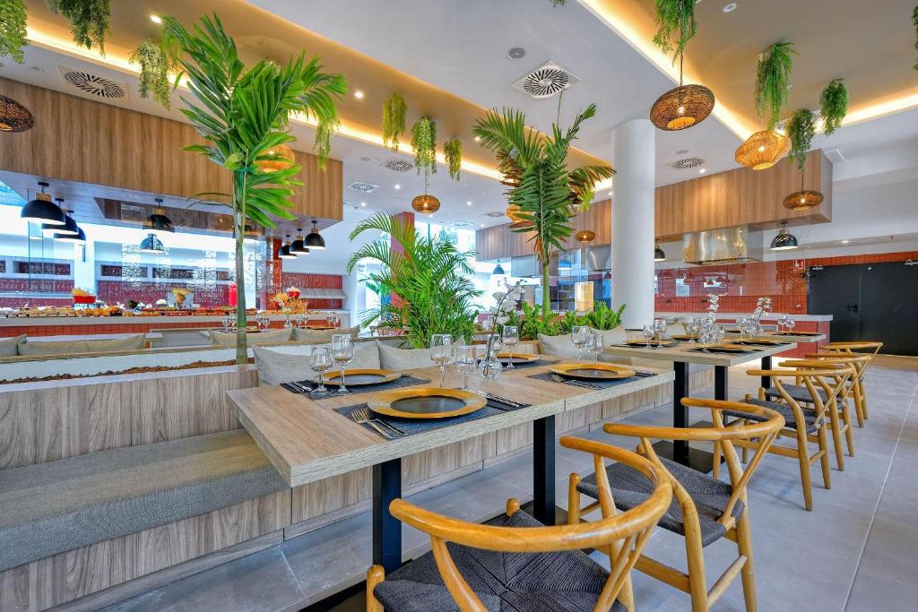 Mūsdienīgs restorāns ar zaļumu akcentiem un elegantiem galdiem, kas nodrošina patīkamu ēdināšanas vidi. Interjers apvieno dabīgus elementus un modernu dizainu.