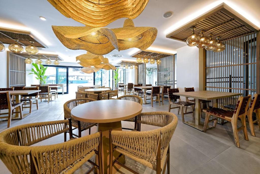 Mūsdienīgs restorāna interjers ar dabīgām materiālu akcentiem, iekārtotiem galdiem un krēsliem, kā arī stilīgām lampām, kas radījušas patīkamu atmosfēru.