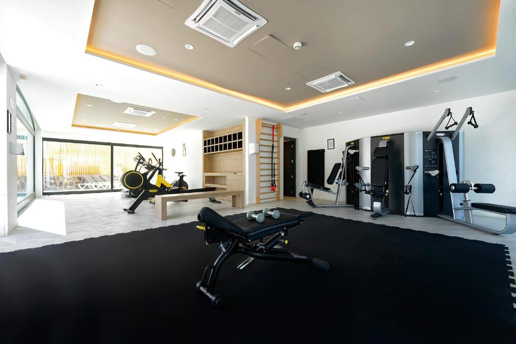 Mūsdienīga sporta zāle ar dažādām treniņu iekārtām, melnu paklāju un daudz gaismas. Ideāla vieta fitnesa treniņiem un aktīvai dzīvesveida uzturēšanai.