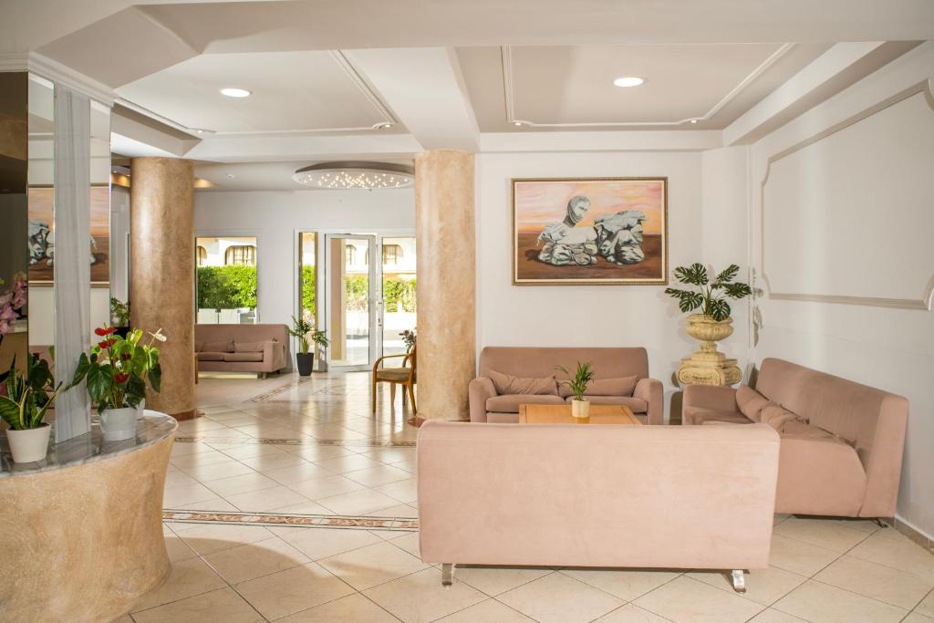 Mūsdienīgs viesnīcas interjers ar gaišām krāsām, sofām un augu dekorācijām, kas rada viesmīlīgu atmosfēru. Izcila glezna papildina telpas estētiku.