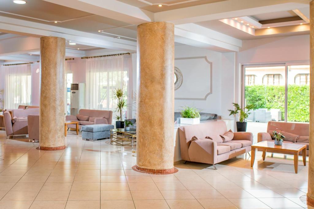 Mūsdienīga viesnīcas recepcija ar ērtām mēbelēm un plašu telpu, kas papildināta ar augiem un dabīgu apgaismojumu.