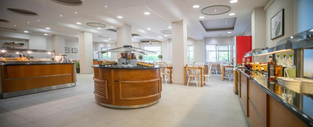 Mūsdienīgs restorāns ar gaišu interjeru un ērtām ēdamzonām, kurā redzami bufetes galdi un koka krēsli. Ideāla vieta relaksācijai un maltīšu baudīšanai.