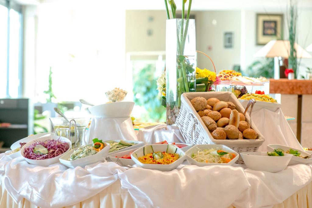 Bagātīga svētku bufete ar dažādām salātiem, maizēm un dārzeņu ēdieniem, kas pasniegta elegantā vidē. Ideāli piemērota svinībām un pasākumiem.