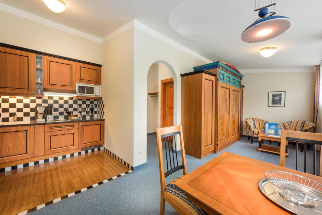 Mūsdienīgs dzīvoklis ar koka virtuvi un ēdamgaldu, kurā ir komfortabla atpūtas zona. Interjers apvieno tradicionālo un modernu stilu.