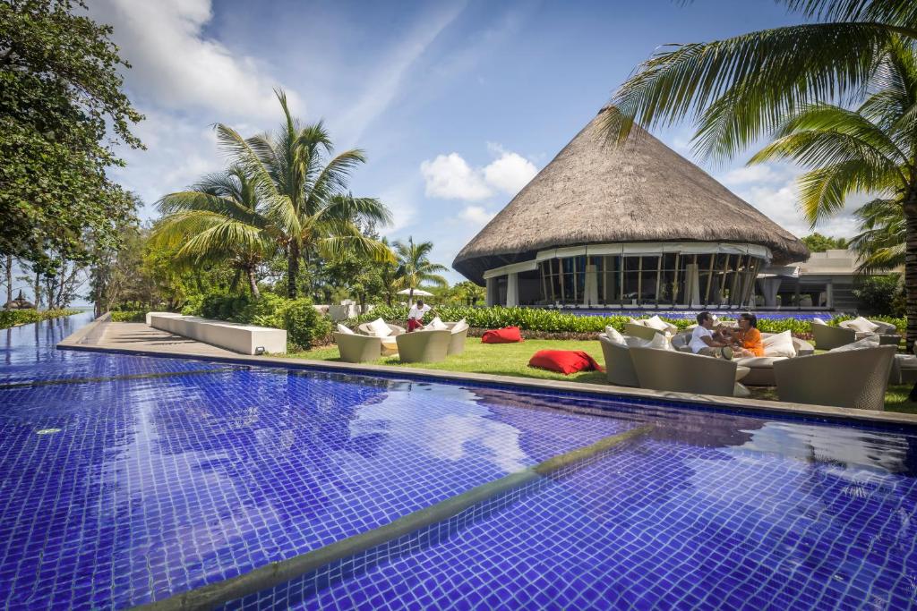 Tropu kūrorts ar peldbaseinu un palmām, ap kuru ir zaļumi un moderns bārs ar saldiem dīvāniem. Ideāla vieta atpūtai un relaksācijai.