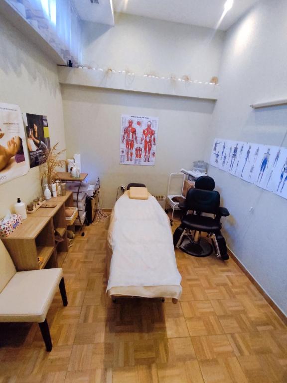 Masāžas telpa ar gultu, anatomijas plakātiem un ērtu krēslu. Telpa ir gaiša un mājīga, paredzēta relaksācijai un terapijai.