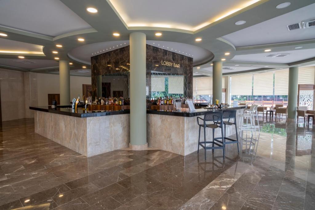 Mūsdienīgs lobby bārs ar elegantām marmora grīdām un plašu dzērienu izvēli, kas gaida viesus. Apgaismojums un interjers rada patīkamu atmosfēru.