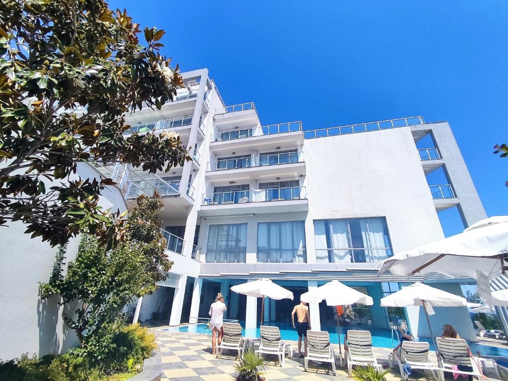 Mūsdienīga viesnīca ar baseinu un saules krēsliem, apkārtne ar zaļumiem un skaidru zilu debesi. Ideāla vieta atpūtai un relaksācijai.