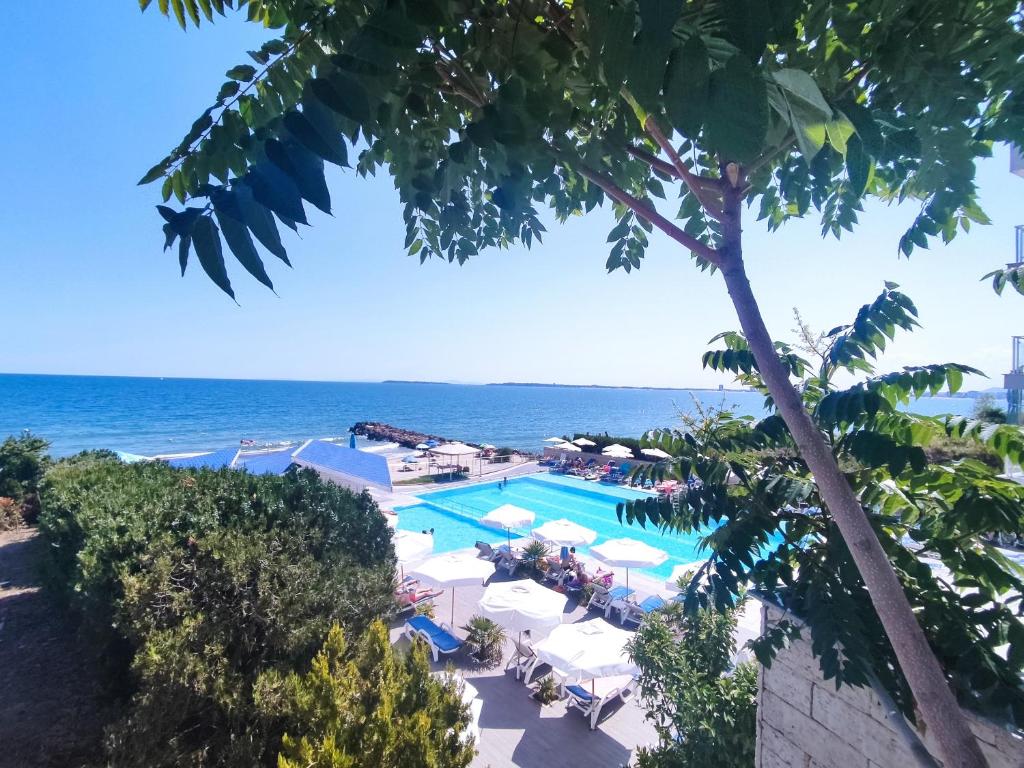 Jūras skats ar baseinu un sauļošanās krēslām, apzaļumots ar kokiem un krūmiem. Ideāla vieta atpūtai un relaksācijai.