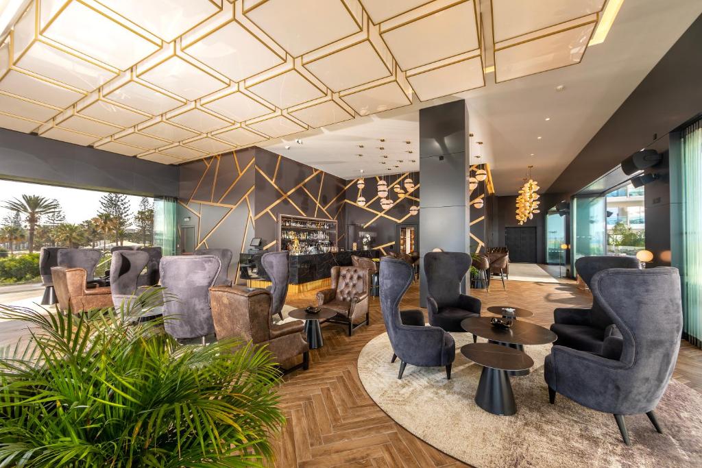 Mūsdienīgs viesnīcas interjers ar elegantiem krēsliem un stilīgu apgaismojumu, radot relaksējošu atmosfēru. Lieliski piemērots atpūtai un socializēšanai.