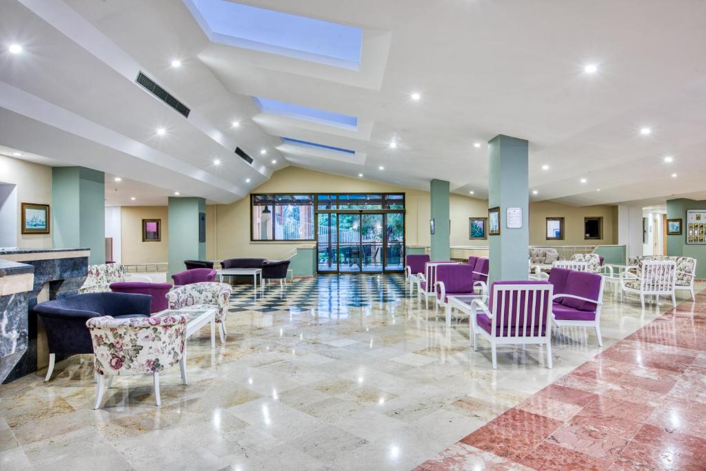 Moderns viesnīcas Asteria Collection Side reģistratūras laukums ar ērtiem krēsliem