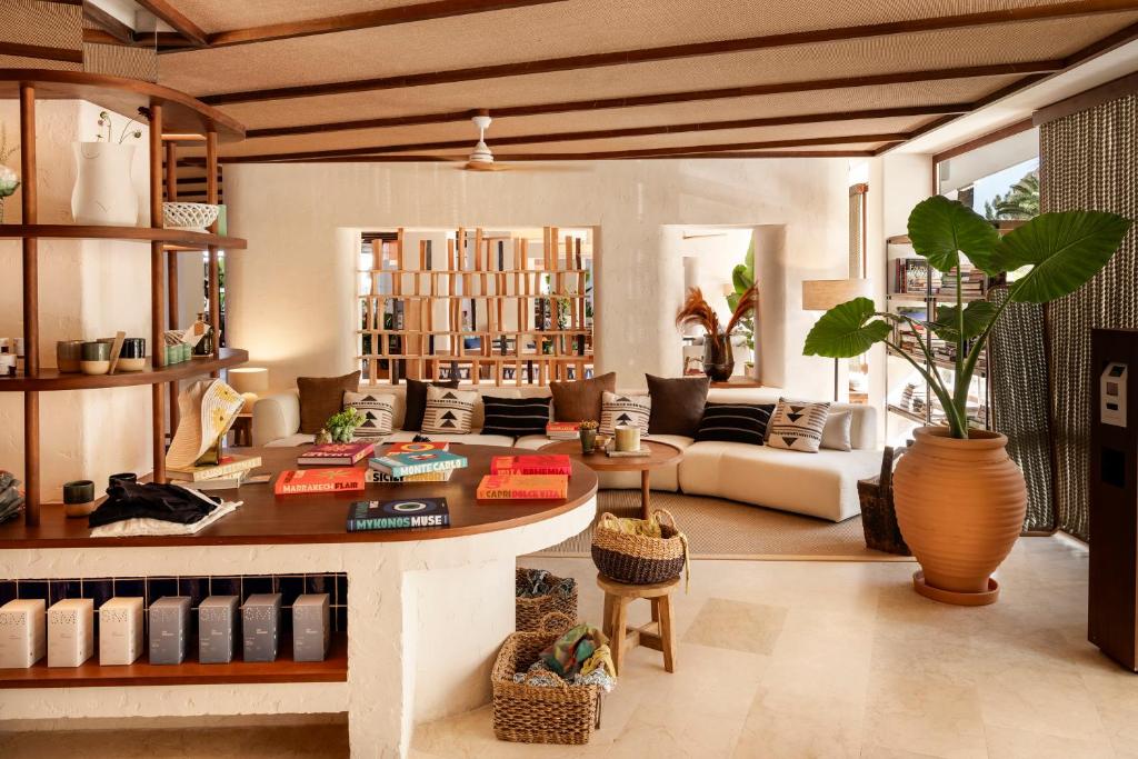 Mūsdienīga un stilīga viesnīcas reģistratūra ar ērtām mēbelēm, dekoratīviem elementiem un daudzām zaļām augiem, radot viesmīlīgu atmosfēru.