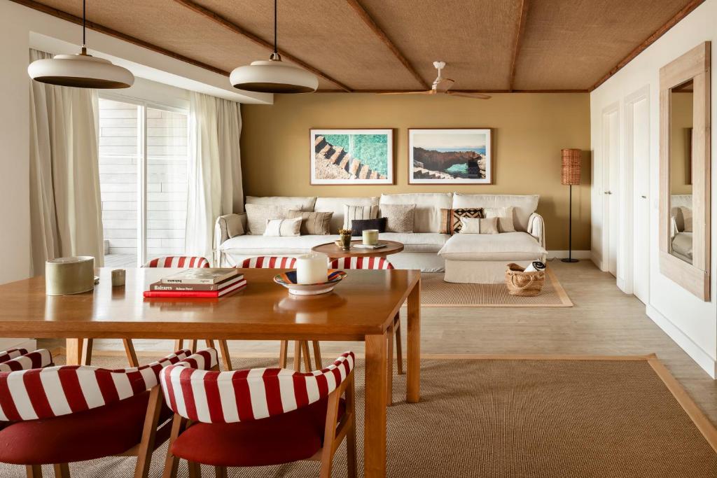 Mūsdienīga viesistaba ar gaišu krāsu paleti, ērtiem dīvāniem un stilīgām, svītrainām krēslām, kas papildināta ar mākslas darbiem uz sienām un dabīgiem elementiem. Ideāla telpa atpūtai un socializēšanai.