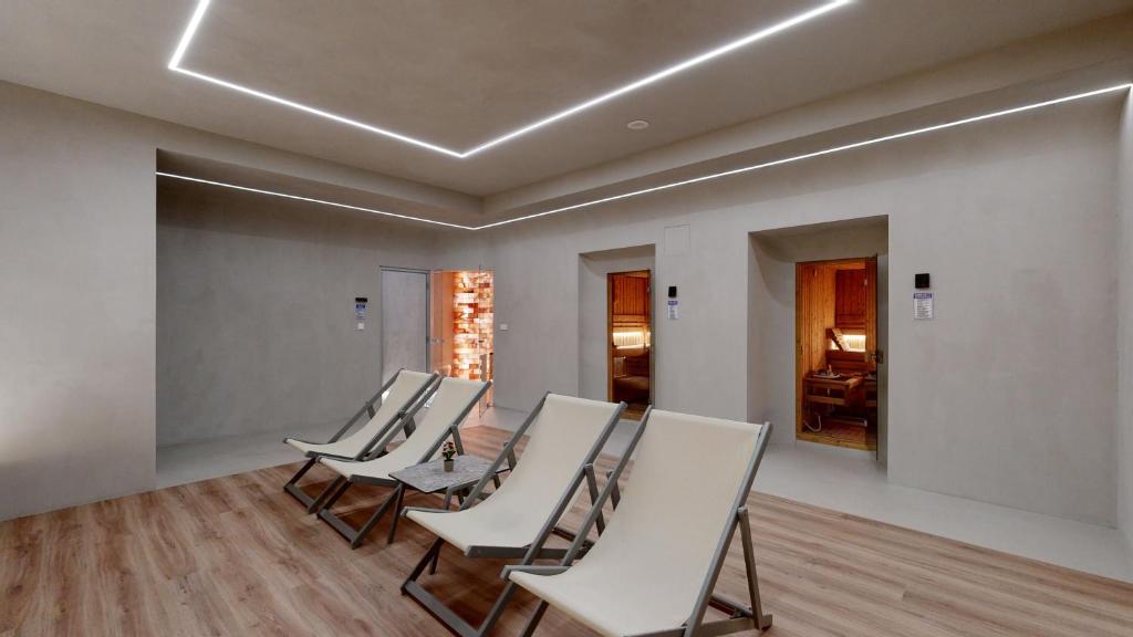 Mūsdienīga relaksācijas telpa ar guļamkrēsliem un minimālistisku interjeru, kas ietver dažādas saunas. Gaismas elementi piešķir siltu atmosfēru.