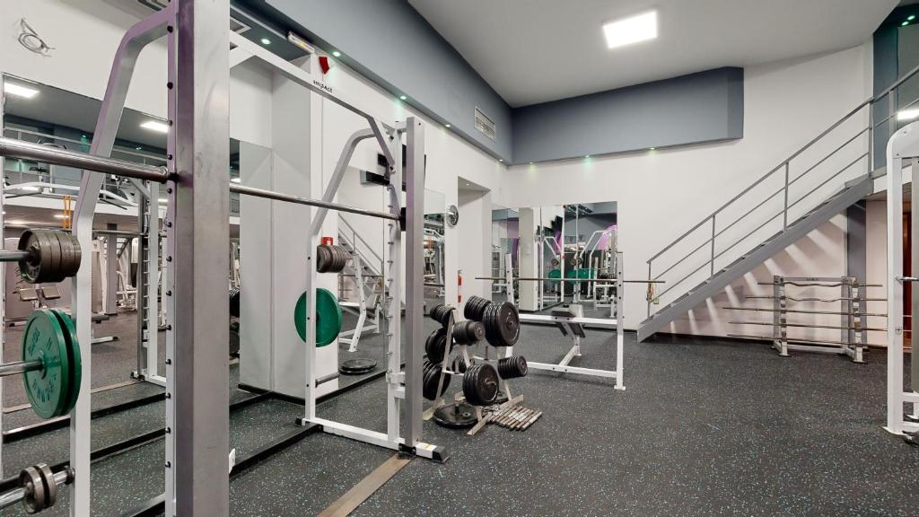 Sporta zāle ar dažādiem treniņu aprīkojumiem, tostarp svaru stieņiem un smaguma plāksnēm. Telpa ir gaiša un moderna, ar spoguļiem un kāpnēm uz otro stāvu.