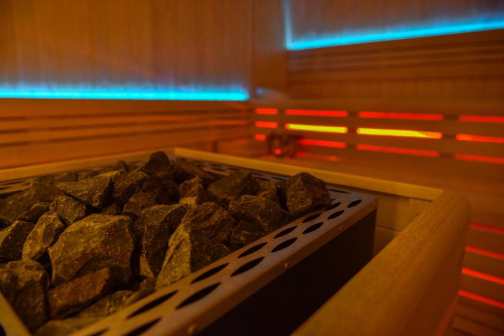 Saunas akmeņi atpūtas telpā ar modernu apgaismojumu. Siltuma avots un relaksācijas atmosfēra.