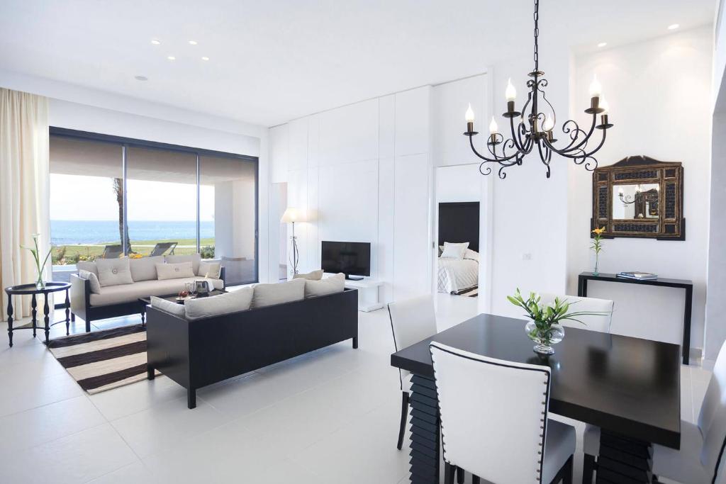 Moderns interjers ar viesistabu un ēdamzonu, kas piedāvā skatu uz jūru. Gaismas elementi un eleganta mēbelēšana rada patīkamu atmosfēru.