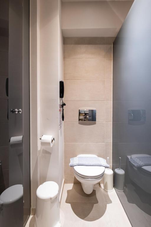 Mūsdienīga vannas istaba ar tualeti, dušas kabīni un nepieciešamajām higiēnas precēm. Telpa ir gaiša un funkcionāla, ar minimālistisku dizainu.