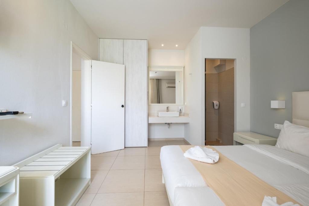 Mūsdienīga viesnīcas numura interjers ar gaisīgu atmosfēru, kas ietver baltu gultu un minimālistisku mēbeļu dizainu. Numurā ir pieejama vannas istaba un atsevišķa zonas ar spoguli.