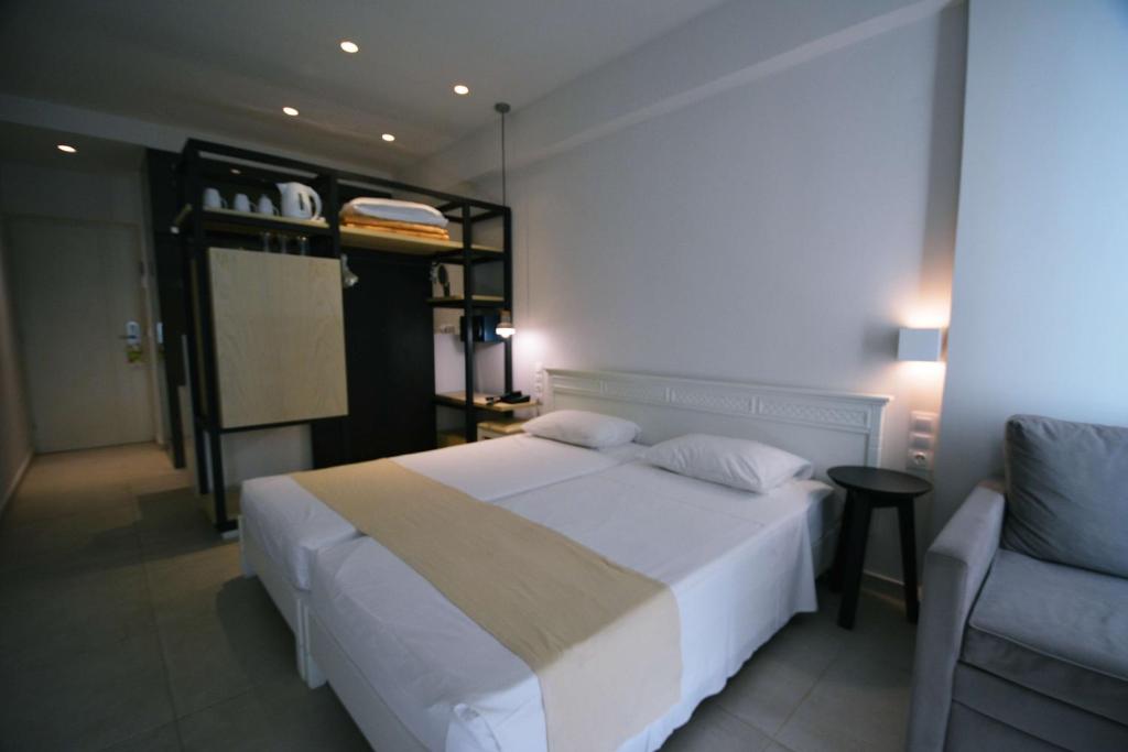 Moderns viesnīcas numurs ar divām atsevišķām gultām, minimālistisku dizainu un ērtu dīvānu. Telpā ir plaukti ar traukiem un gultas veļa, kā arī gaiša apgaismojuma elementi.