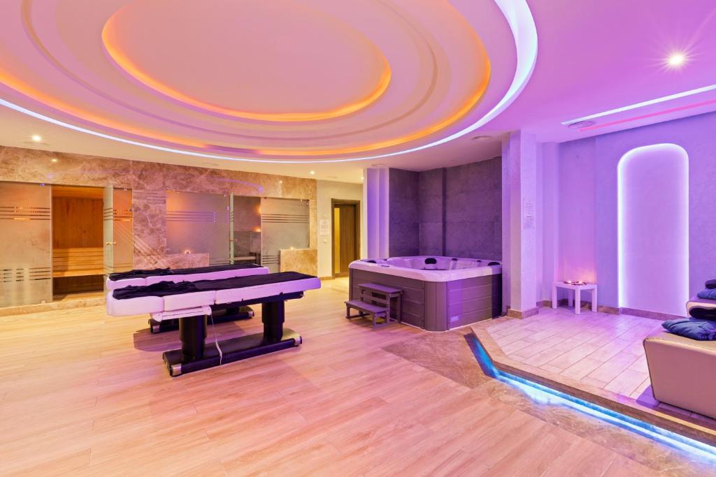 Mūsdienīgs spa ar relaksējošu atmosfēru, kurā redzami masāžas galdi, burbuļvanna un mīksti sēdekļi. Interjerā ir maiga apgaismojuma un dabisko materiālu kombinācija.