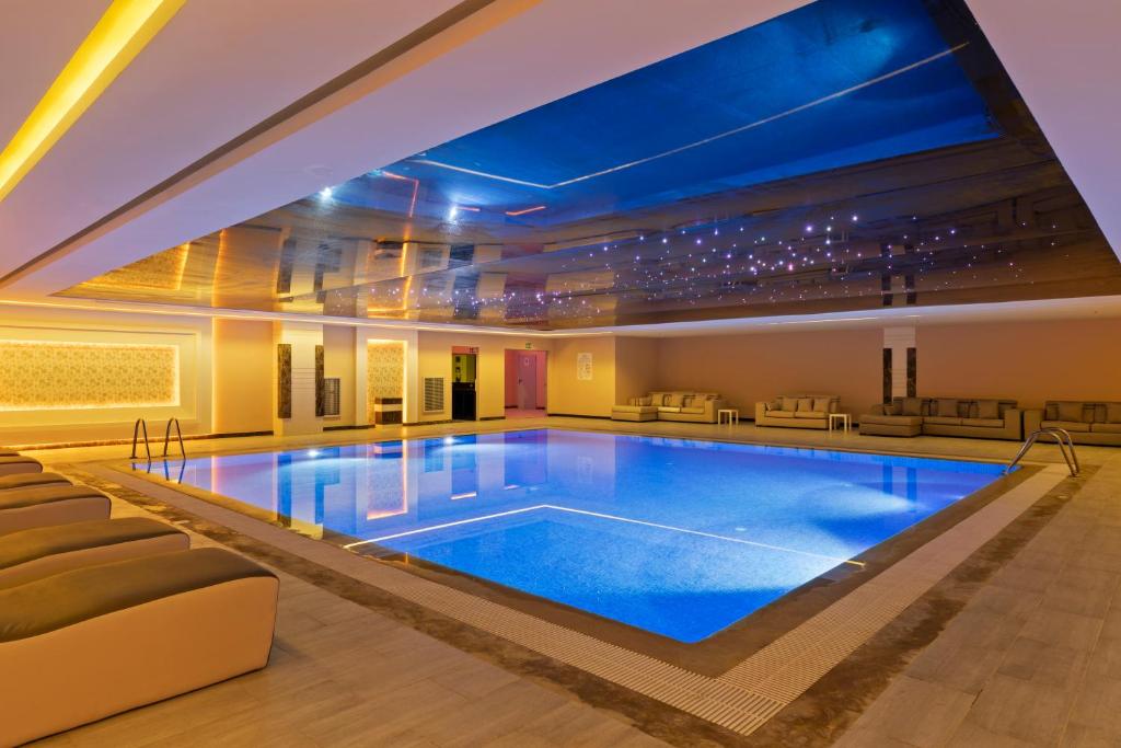 Luksusa iekštelpu peldbaseins ar mīkstiem dīvāniem un mūsdienīgu apgaismojumu, kas radīs relaksējošu atmosfēru. Ūdens spīd un atspoguļo griestus, piešķirot telpai īpašu šarmu.