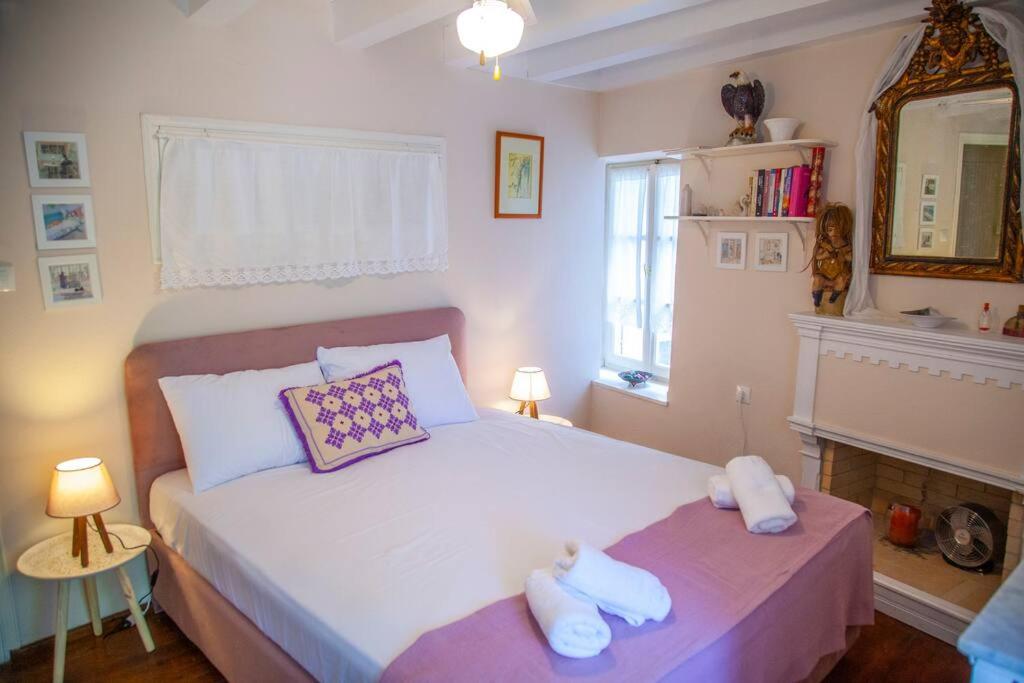 Mūsdienīgs viesnīcas numurs ar gultu un dekoratīvām spilveniem, siltām gaismām un elegantiem interjera elementiem, radot mājīgu atmosfēru.