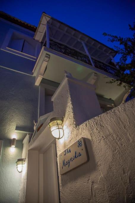 Mājīga un elegantā ēka ar nosaukumu "The Magnolia", izgaismota pievakarē, radot patīkamu atmosfēru.