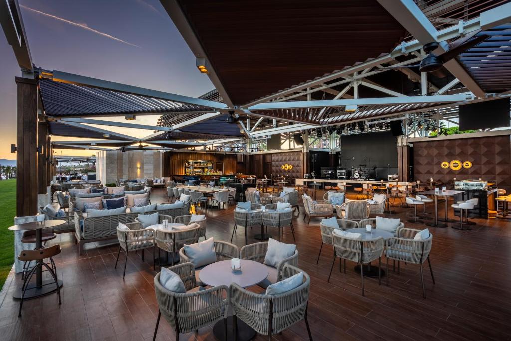 Moderns restorāns ar stilīgu terasi, kas piedāvā ērtas sēdvietas un bāra zonu, ideāli piemērots relaksācijai un socializēšanai. Apgaismojums un arhitektūra rada patīkamu atmosfēru.