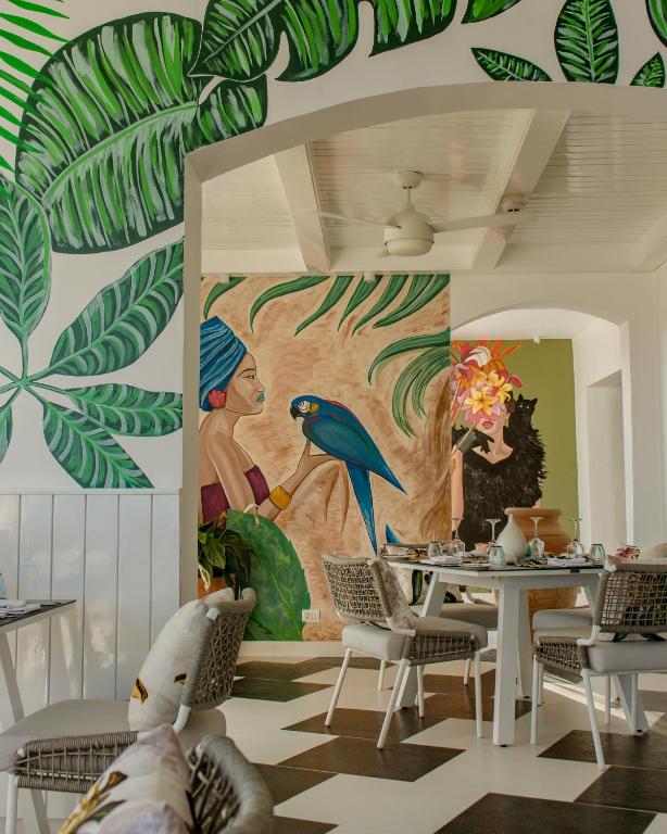 Fort Arabesque Resort, Spa & Villas restorāns ar tropiskiem sienas gleznojumiem.