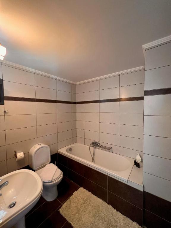 Panorama Village Hotel numura vannas istaba ar vannu un gaišām flīzēm