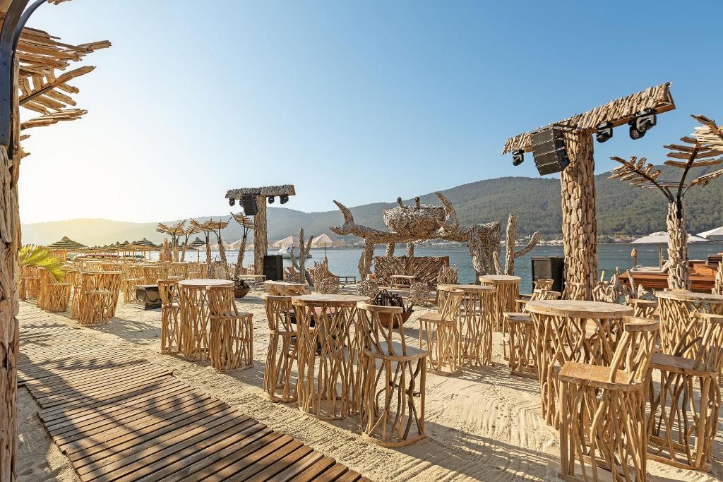 Viesnīcas Titanic Luxury Collection Bodrum pludmales bārs ar dabīgu koka mēbelēm.