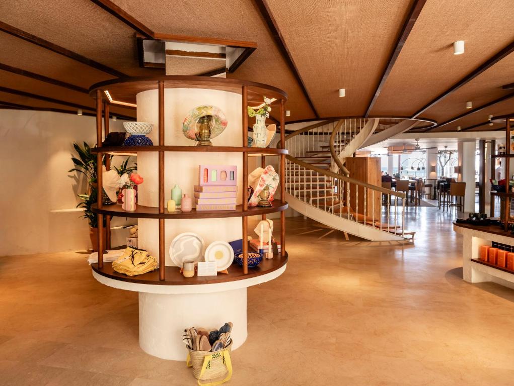 Mūsdienīgs interjers ar stilīgu stendu, kas piedāvā dažādus mājas dekora priekšmetus, un spiralveida kāpnes, kas ved uz augšu.