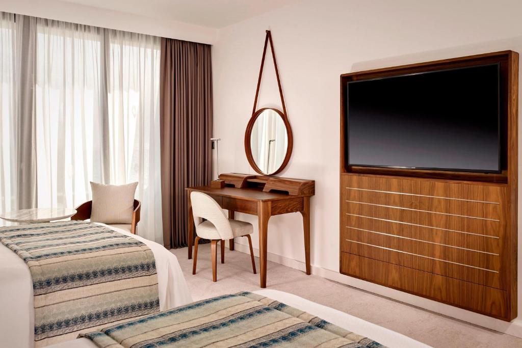 Mūsdienīgs viesnīcas numurs ar divām gultām, koka mēbelēm un televizoru, kā arī plašiem logiem ar aizkariem. Numurā ir rakstāmgalds un atpūtas zona.