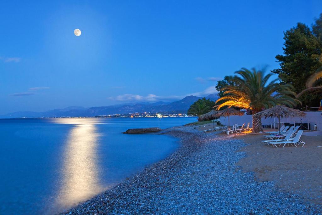 Skaista pludmale zem pilnīgas mēness gaismas, ar palmām un pludmales krēsliem, kas izveidoti relaksējošai atmosfērai. Ūdens spoguļo gaismu, radot mierīgu noskaņu.