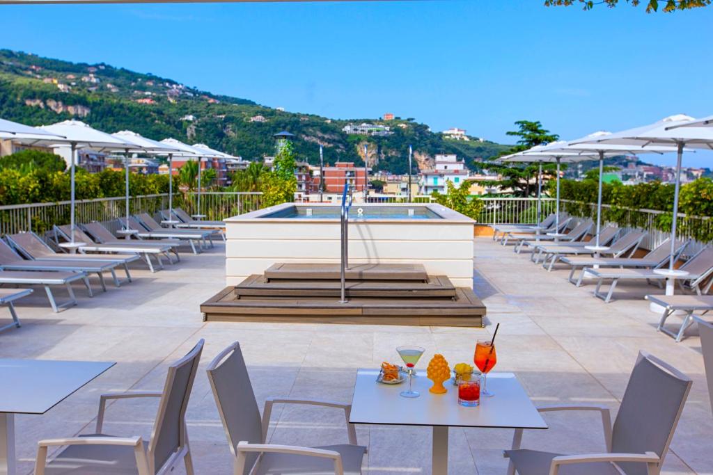 Lieliska atpūtas zona ar sauļošanās krēsliem, baseinu un kokteiļiem uz galda, skats uz kalniem un pilsētu. Ideāla vieta relaksācijai un atpūtai.
