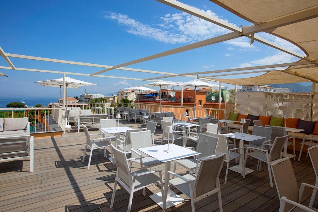 Atvērtā terase ar ērtām mēbelēm un saulessargiem, redzama jūra un debesis. Ideāla vieta relaksācijai un atpūtai.