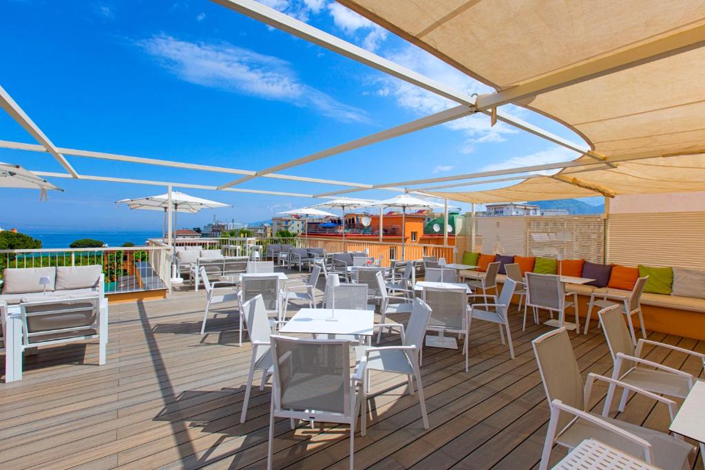 Terases zona ar modernām mēbelēm un saulessargiem, izceļot skatu uz jūru un debesīm. Ideāla vieta relaksācijai un ēdināšanai brīvā dabā.