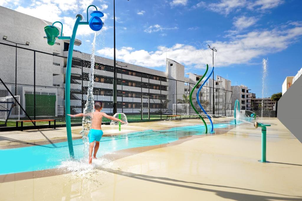 Bērns spēlējas ūdens atrakcijās Hovima Suite Costa Adeje.