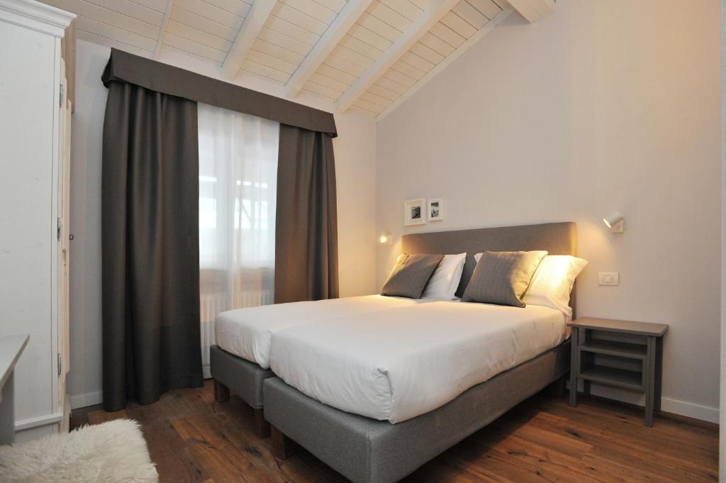 Mūsdienīga guļamistaba ar divguļamo gultu, gaišiem toņiem un koka grīdu, papildināta ar elegantiem aizkariem un naktsgaldiņu. Ideāla vieta atpūtai un relaksācijai.