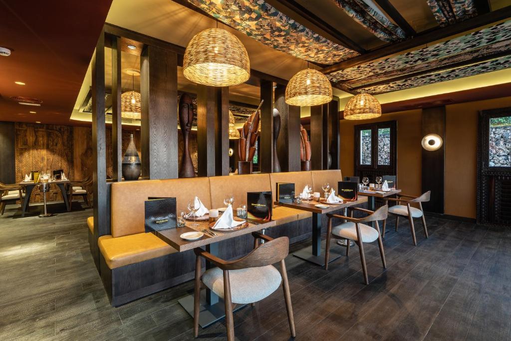 Mūsdienīgs restorāns ar elegantām koka apdarēm un rotājumiem, kas rada siltu un viesmīlīgu atmosfēru. Gaismas lampas un izsmalcināts galda klājums papildina interjeru.