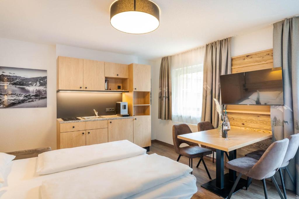 Mūsdienīgs viesnīcas numurs ar koka mēbelēm, virtuvīti un ēdamgaldu. Interjērā ir gaišas krāsas un ērti krēsli, radot patīkamu atmosfēru.