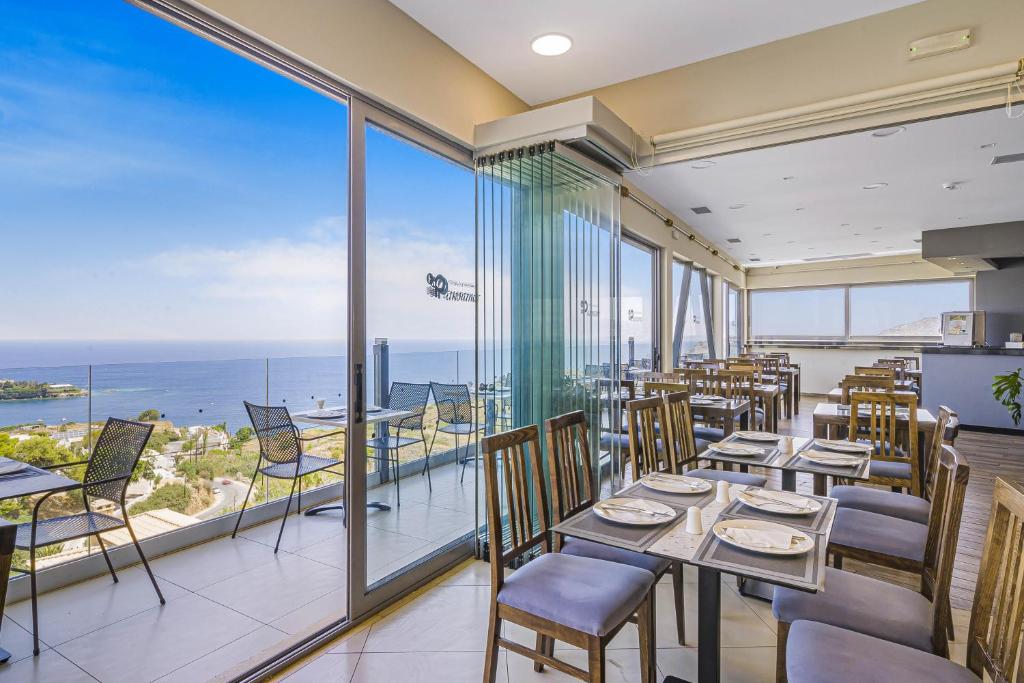 Panorama Village Hotel restorāns ar plašiem logiem un panorāmas skatu uz piekrasti un jūru