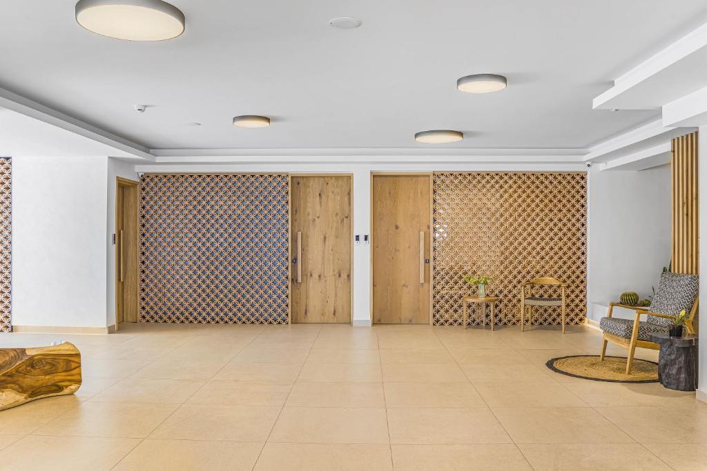 Moderns Panorama Village Hotel vestibila interjers ar koka dekoriem un gaišu atmosfēru.