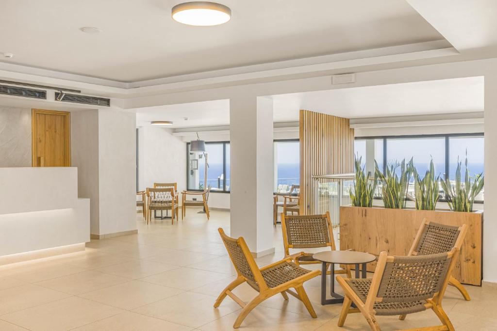 Panorama Village Hotel gaišs vestibils ar koka mēbelēm un skatu uz jūru