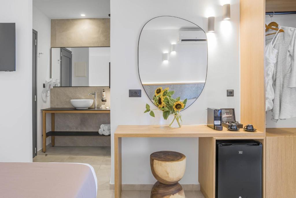 Panorama Village Hotel numura interjers ar modernu koka galdu, kafijas automātu un vannas istabu fonā