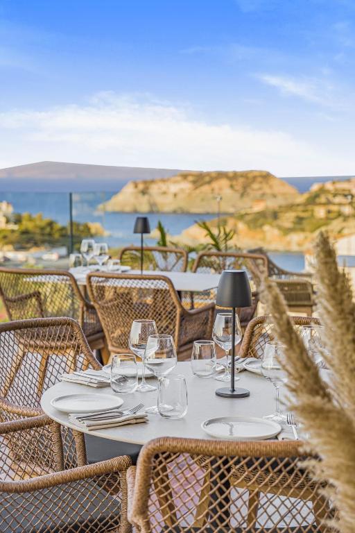 Panorama Village Hotel restorāna terase ar servētiem galdiem un skatu uz piekrasti