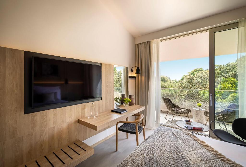 Mūsdienīgs viesnīcas numurs ar plašu balkonu, koka apdari un ērtu darba staciju. Skats uz dabu caur lielajiem logiem rada mierīgu atmosfēru.