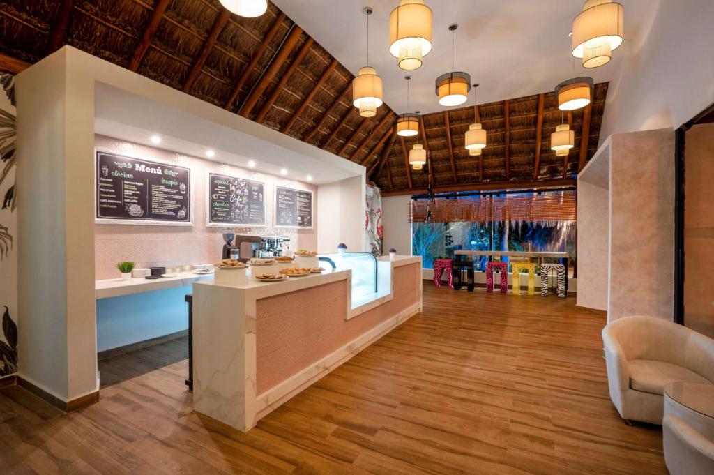Mūsdienīgs kafijas bārs ar gaišu interjeru, dekorēts ar rattan griestiem un stilīgām lampām, piedāvā dažādus dzērienus un uzkodas. Logi sniedz skatu uz dabu, radot patīkamu atmosfēru.