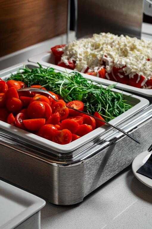 Svaigu tomātu un zaļumu bufete, ideāli piemērota veselīgām maltītēm un salātiem. Pievienotās sastāvdaļas rada krāsainu un pievilcīgu prezentāciju.